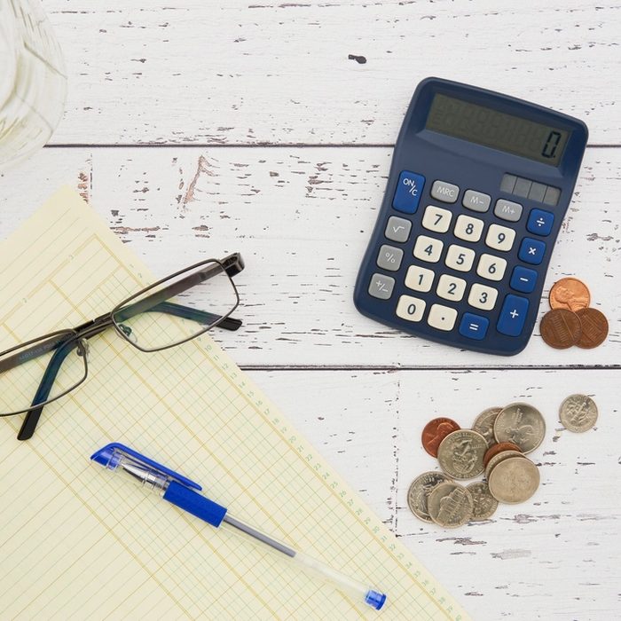 Calculadora, monedas y gafas para el curso de finanzas personales